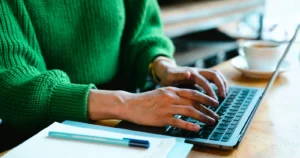 Persona consultando información en una computadora portátil antes de presentar un formulario a USCIS